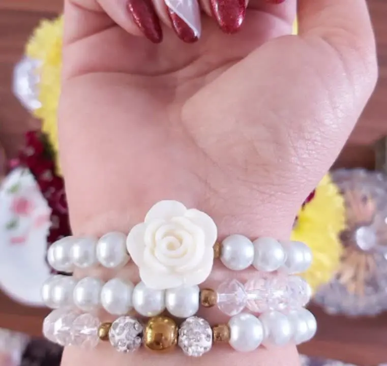 ست دستبند از سه دستبند کشی که از گل سرامیکی و گوی نگین دار سفید و حدید گرد
