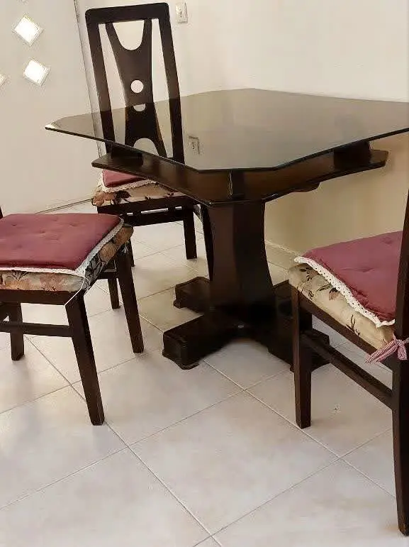 میز ناهارخوری ۴ نفره همراه ۴ صندلی. صندلیها قدیمی ولی محکمه. خط و خش داره.